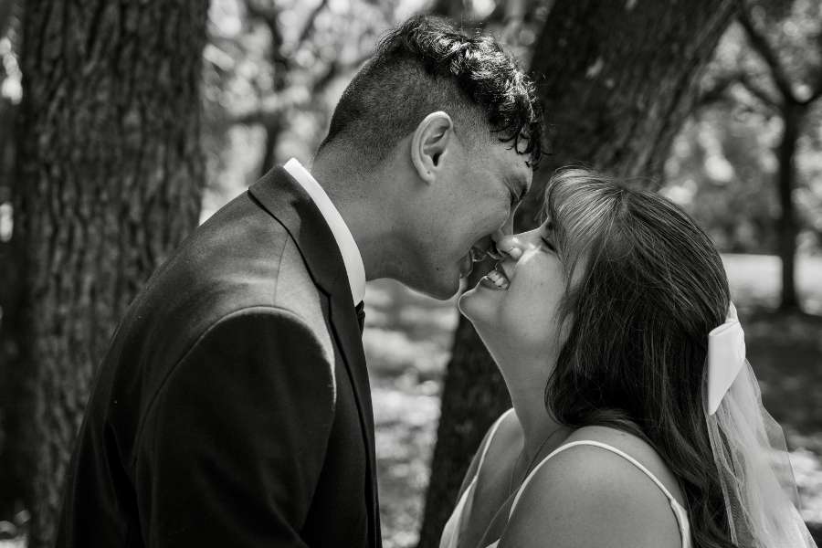 Couple de mariés riant nez à nez en noir et blanc par un photographe de mariage