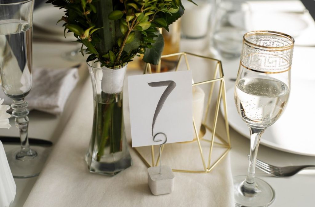 Décoration de table de mariage avec numéro 7 et verrerie raffinée pour creer un hashtag de mariage original.